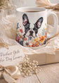 Mug with a dog illustration and floral design, placed on a gift box with decorative elements.